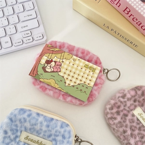 Dettaglio di pochette in peluche leopardato rosa e blu con cerniera metallica e gancio