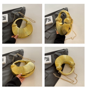 Gros plan du sac de soirée doré en demi-lune avec texture ondulée et bandoulière chaîne