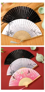 Detail view of colorful folding fans with silk fabric and elegant tassels on bamboo ribs