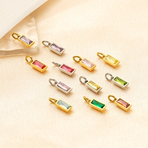Detailed macro view of colorful rectangular zircon pendants on silk fabric background