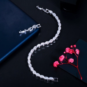 Detailed macro view of a silver cubic zirconia tennis bracelet with an extra clasp accessory