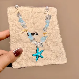 Detail of beach style shell ceramic necklace with blue beads and starfish pendant
