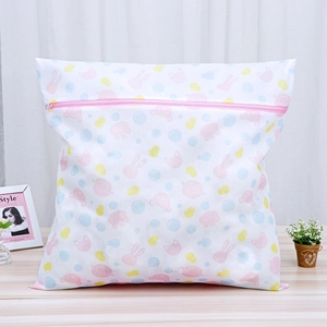 Detail of a fine mesh laundry bag with cute cartoon rabbit print and pink protective zipper