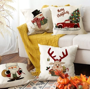 Vierer-Set Weihnachts-Kissenbezüge mit Weihnachtsmann und Rentier auf einem beigen Sofa