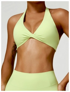 Close-up of lime green halter yoga top with twist detail and high-waisted leggings