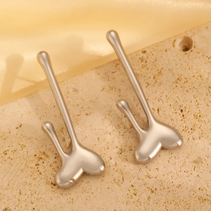 Detailed view of silver fluid lava earrings on stone and silk fabric background