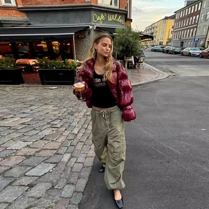 Women's trendy red glossy cropped puffer jacket styled with casual street fashion vibes