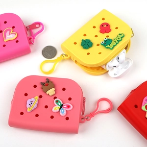 Three colorful silicone coin purses in pink, yellow, and red with cute cartoon charms