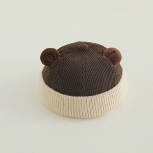 Close-up of knit texture and cute bear ears on a brown and beige kids' beanie hat