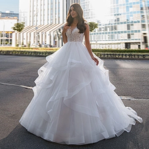 Elegant white V-neck wedding dress with lace bodice and layered tulle ball gown skirt