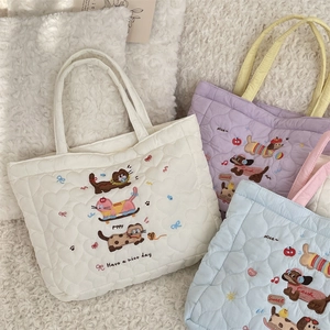 Détail de sacs à main matelassés avec broderies d'animaux en crème, violet et bleu clair