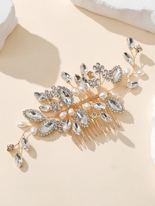 Close-up of handmade bridal hair comb with gold floral rhinestones and white pearls