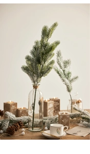 Close-up of artificial flocked pine branch with snow effect in a cozy winter setting