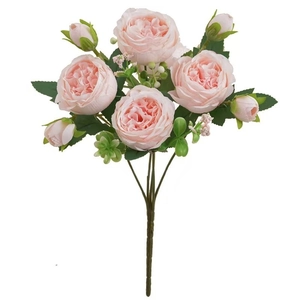 Detailed close-up of realistic pink artificial roses and buds with green leaves on white