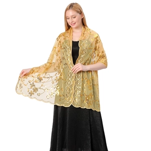 Close-up of exquisite gold sequin floral embroidery on a sheer formal evening shawl
