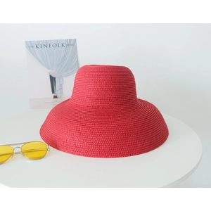 Detailed texture of red wide brim straw hat with fashion magazine and sunglasses