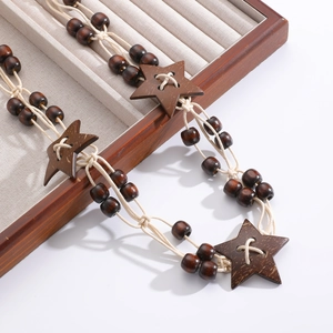 Detail of bohemian wooden star pendant with hand-woven beads and natural grain texture