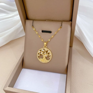 Detail of gold Tree of Life pendant with sparkling crystals in a premium beige gift box