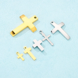 Close-up of assorted stainless steel cross pendants in gold and silver finishes