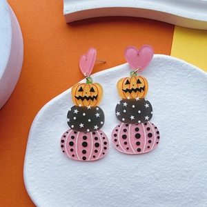 Detailed view of Halloween layered acrylic earrings with pink heart and orange pumpkin patterns