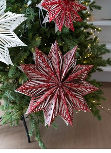 Detailed view of red and white 3D paper snowflake stars hanging on a Christmas tree