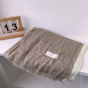 Detail of elegant linen blend scarf with fringe edges and subtle color-block stitching