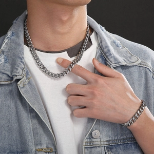 Close-up of 11mm silver Cuban link necklace and bracelet set worn on a male model