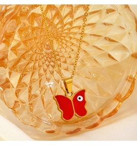 Detail der roten Emaille-Schmetterlings-Halskette mit Evil Eye Anhänger in Glasbehälter