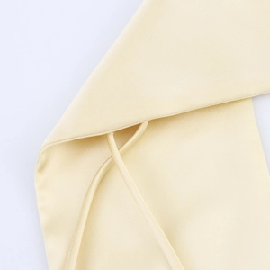 Nahaufnahme des eleganten hellgelben Satin-Kleiderstoffs mit feinen Nähten und Textur