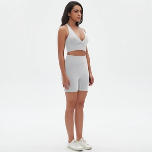 Dettaglio del set yoga grigio chiaro senza cuciture con reggiseno incrociato e short