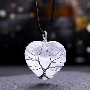 Detail of clear crystal heart pendant with silver wire Tree of Life wrapping