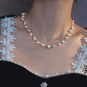 Elegant woven freshwater pearl and gold bead necklace on model with vintage French style