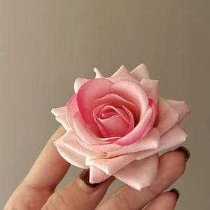 Close-up of pink gradient fabric rose hair claw with delicate floral petal textures