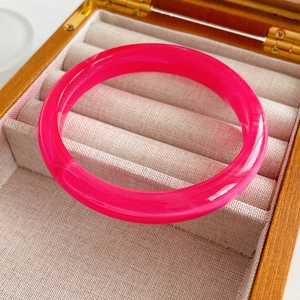 Close-up of bright pink translucent resin bangle in premium velvet lined jewelry box