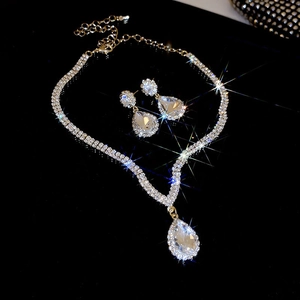 Detailed view of luxury silver teardrop necklace and earrings set with sparkling crystals
