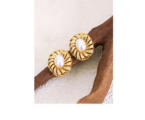 Détail d'une boucle d'oreille spirale dorée avec perle et strass sur bois
