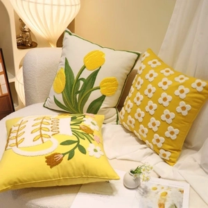 Close-up of floral embroidery on high-end beige and yellow farmhouse decorative pillows
