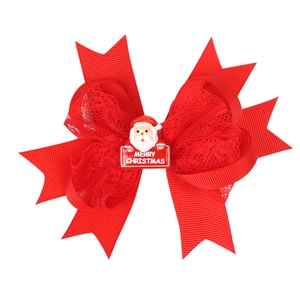 Detail of red Christmas hair clip with ribbon bow and Santa Claus decoration