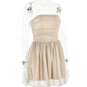 Detailed view of beige strapless dress with ruffled bodice and puffy tulle skirt hem