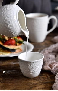 Detail showing non-slip unglazed bottom of the white embossed ceramic tea set