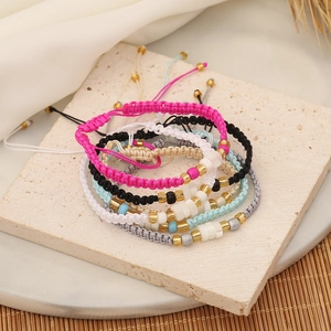 Bohemian seed bead woven bracelets set with shells and gold beads on white stone