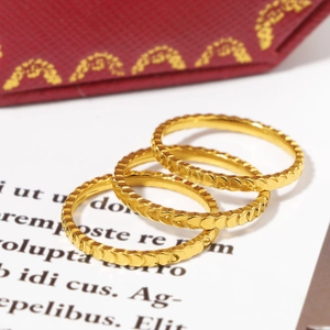Detailed view of three stacked gold titanium rings with textured fish scale engraving