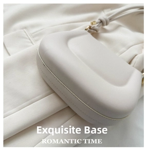Detailed close-up showing the smooth curved bottom and fine texture of an off-white leather bag