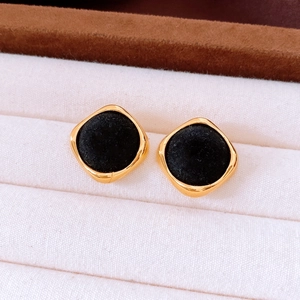 Detailed macro view of vintage gold square earrings with black velvet flocking inlay