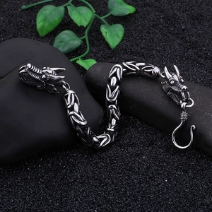 Macro detail of men's stainless steel dragon head bracelet with Byzantine chain link