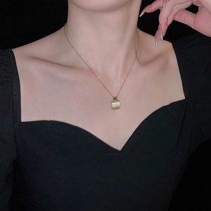 Collier élégant en acier titane doré avec pierre œil de chat carrée sur un mannequin