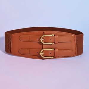Detail of vintage brown wide elastic belt with double gold buckles on a smooth surface
