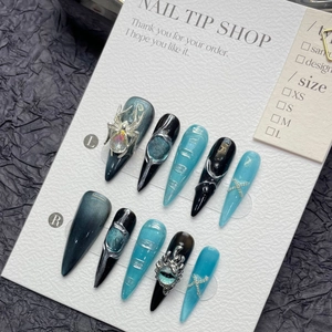 Detailed view of long stiletto press-on nails with spider charms and cat-eye finish