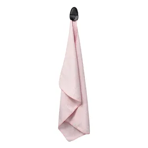 Close-up of pink waffle weave golf towel with textured microfiber and black hook