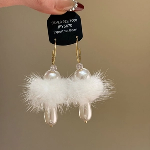 Elegant C-shaped earrings with plush fur balls and white teardrop pearls in gold finish